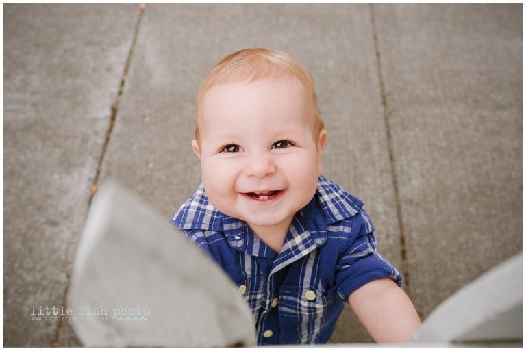 boy smiles while looking over fence