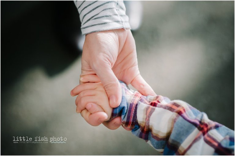 mom hold's baby's hand